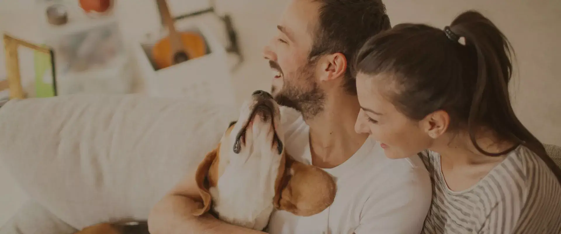 Happy couple hugging their joyful dog